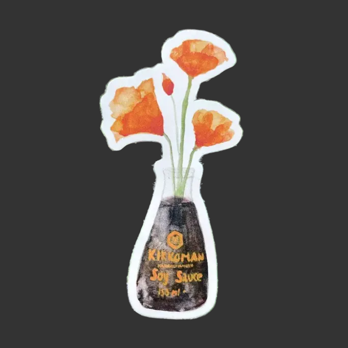 Sticker of a bottle of Kikkoman soy sauce with orange flowers on green leaves